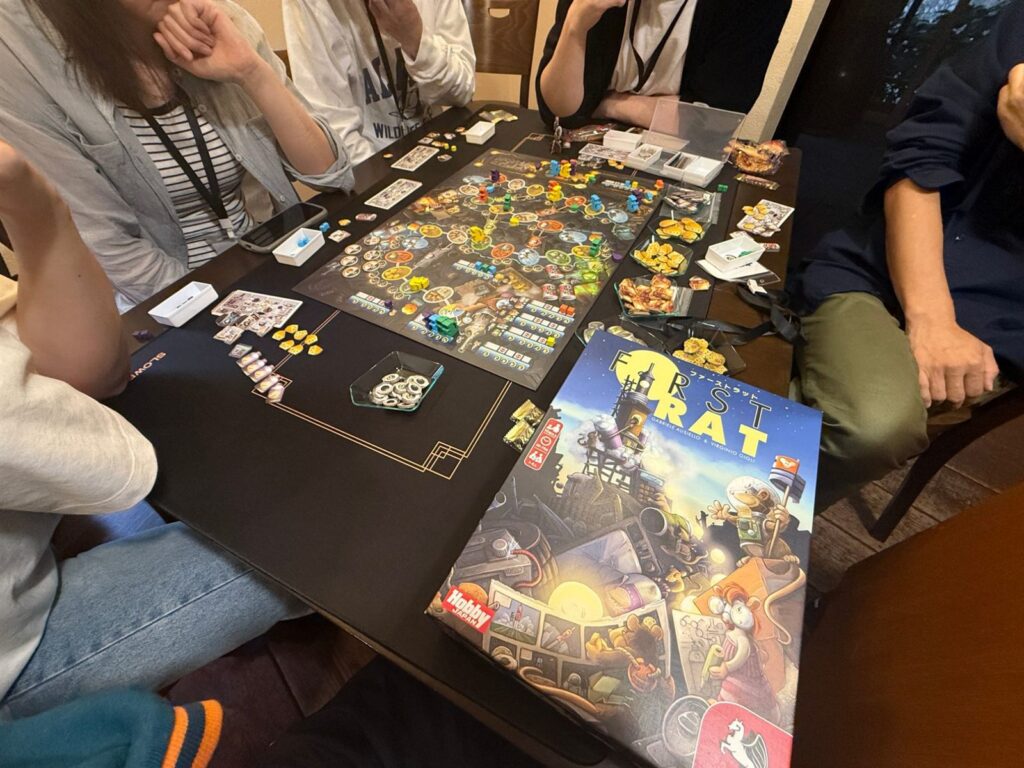 ファーストラットの箱と、コマやタイルが並べられたゲームボード